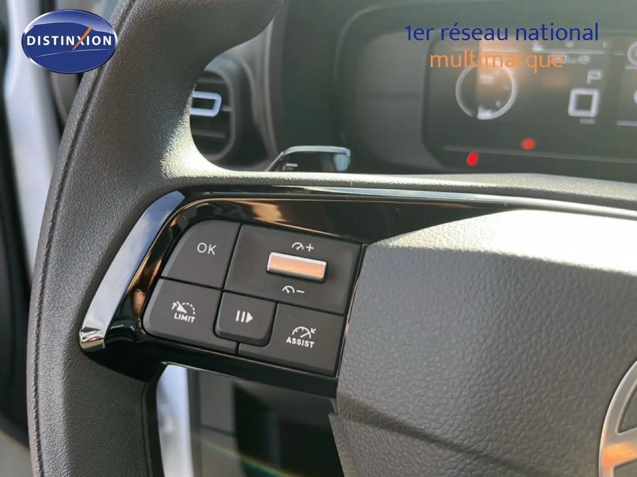 Gros plan sur les commandes au volant côté gauche du Citroën Berlingo blanc Icy 2025 avec régulateur et limiteur de vitesse.