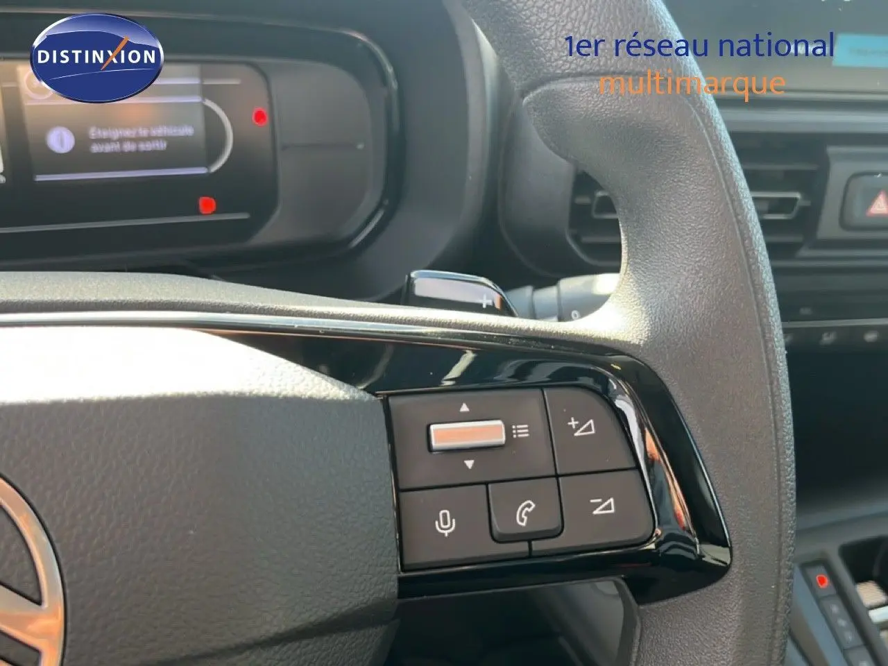 Gros plan sur le volant multifonction noir du Citroën Berlingo 2025, avec commandes audio et téléphone visibles.