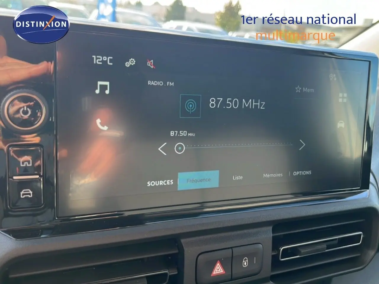 Écran tactile central du tableau de bord du Citroën Berlingo blanc Icy, affichant la radio FM à 87,50 MHz.