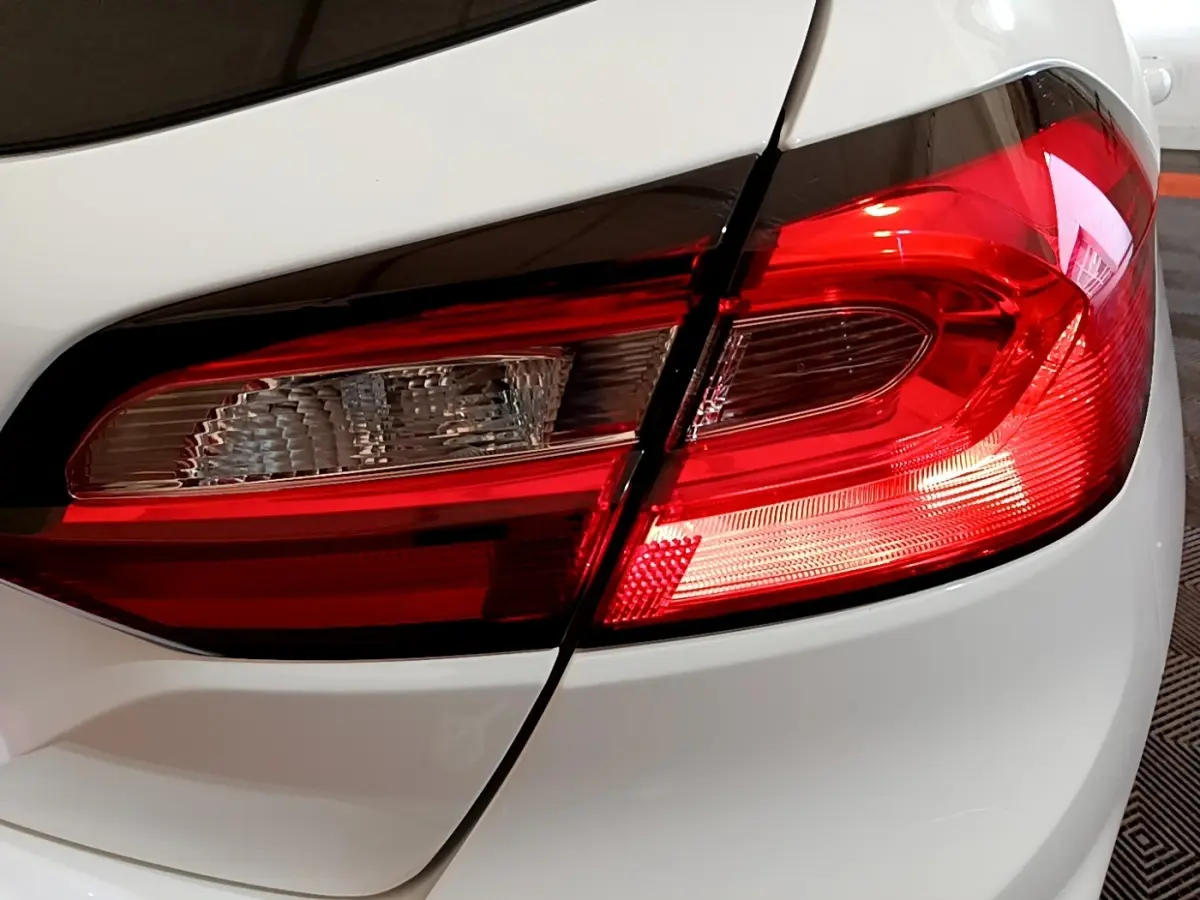 Gros plan sur le feu arrière droit rouge et blanc d'une Ford Fiesta blanche, version 2022, essence.