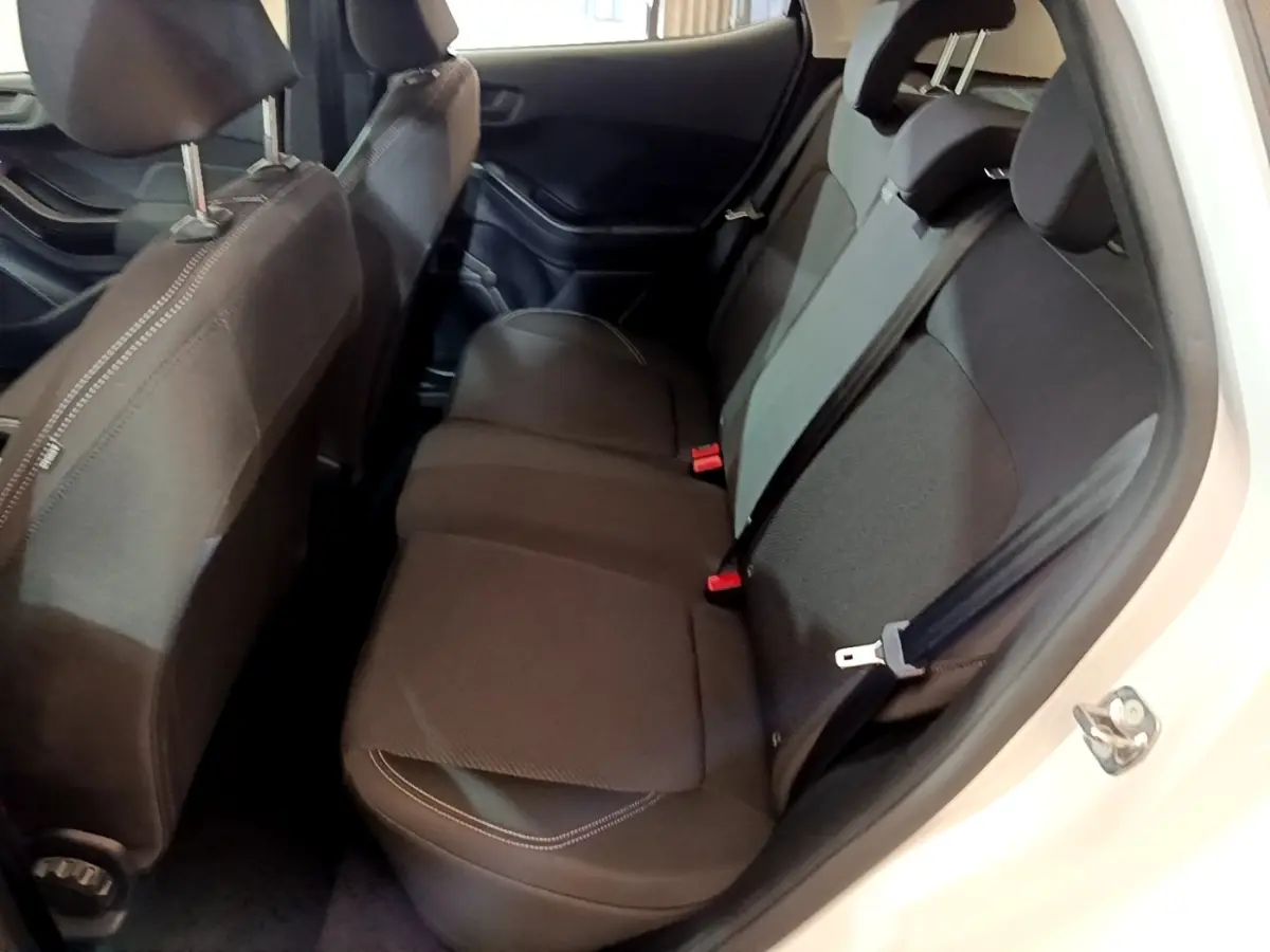 Vue intérieure côté droit montrant la banquette arrière noire de la Ford Fiesta blanche 2022, avec ceintures de sécurité visibles.
