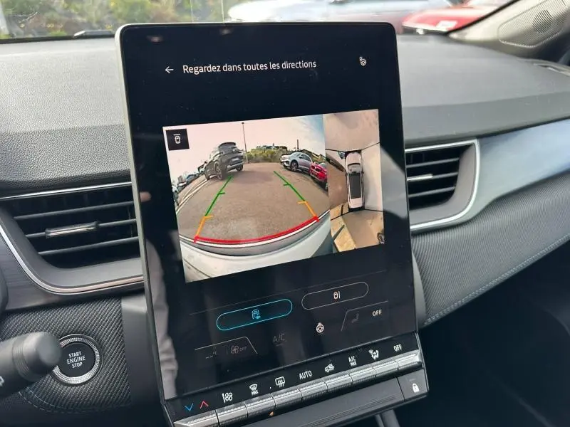 Vue intérieure du tableau de bord du Renault Captur 2026, écran central affichant la caméra de recul avec vue arrière et vue 360° du véhicule blanc nacré/noir étoile.
