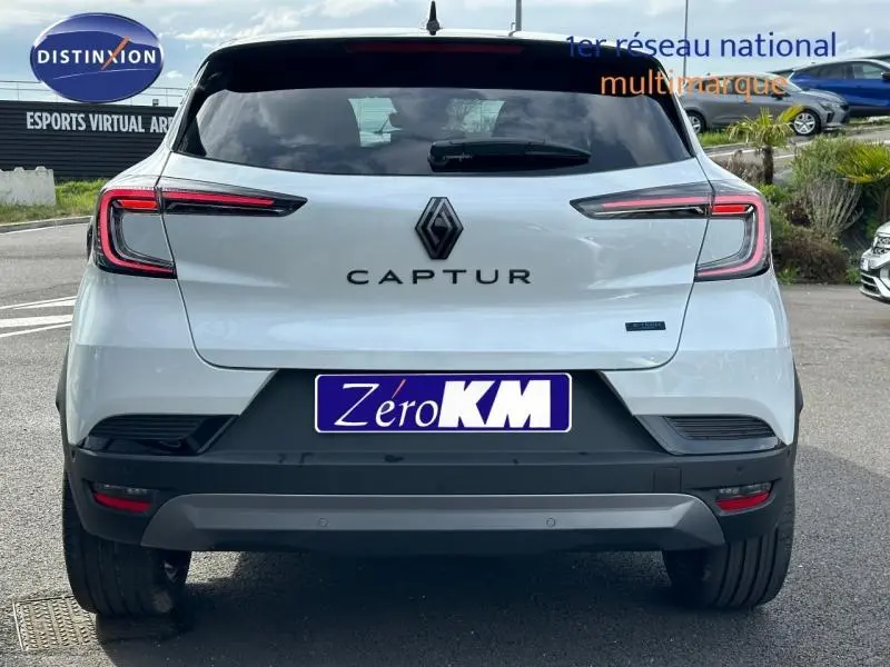 Vue arrière d'un Renault Captur blanc nacré avec toit noir, feux LED distinctifs et logo central bien visible.