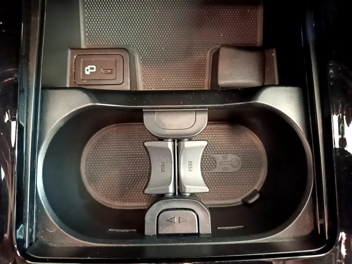 Gros plan sur le rangement central noir avec porte-gobelets et prise USB dans le Mercedes GLB 200 d gris foncé.