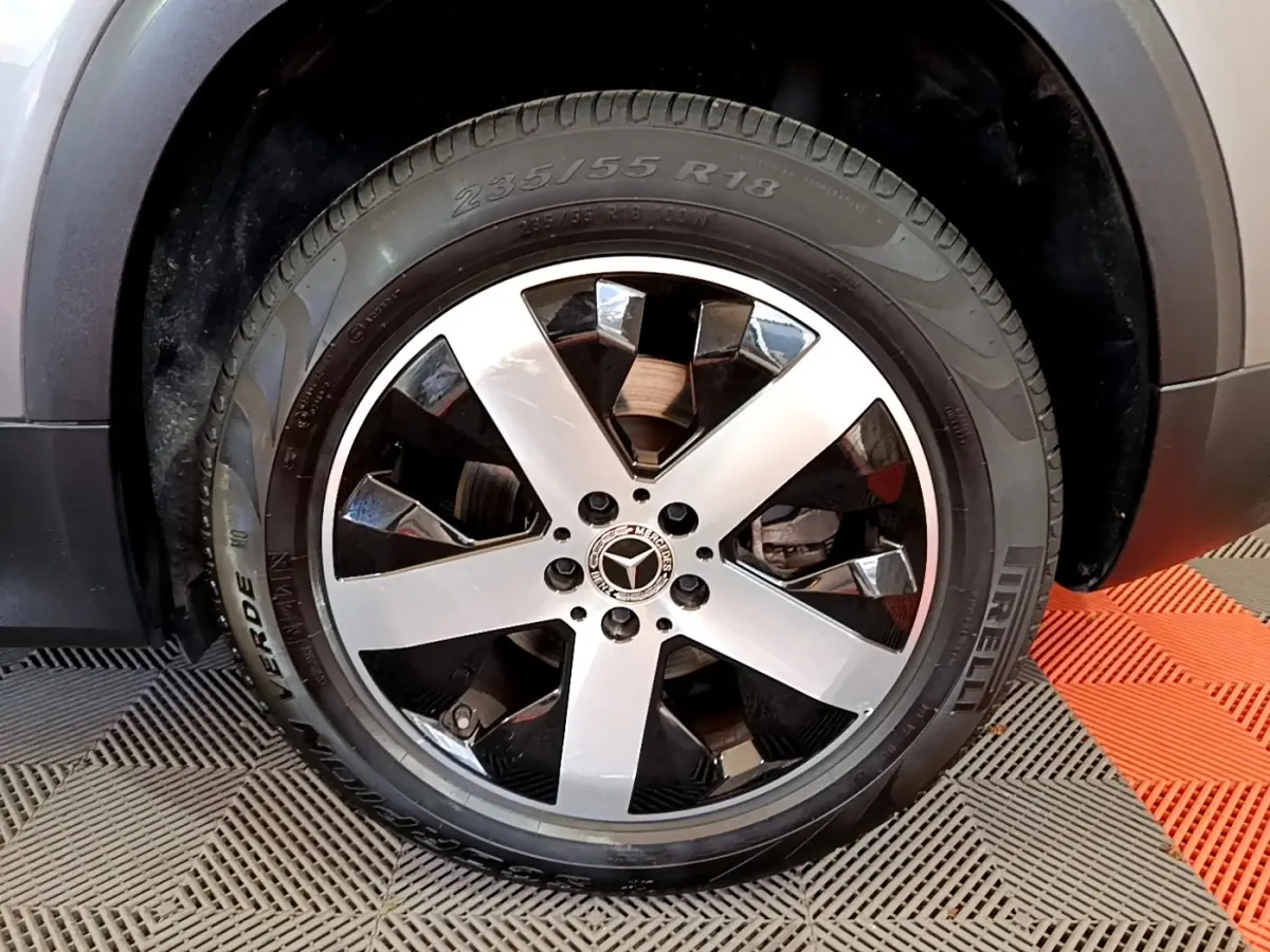 Gros plan sur la roue avant droite avec jante alliage bicolore du Mercedes GLB 200 d Business Line gris foncé.
