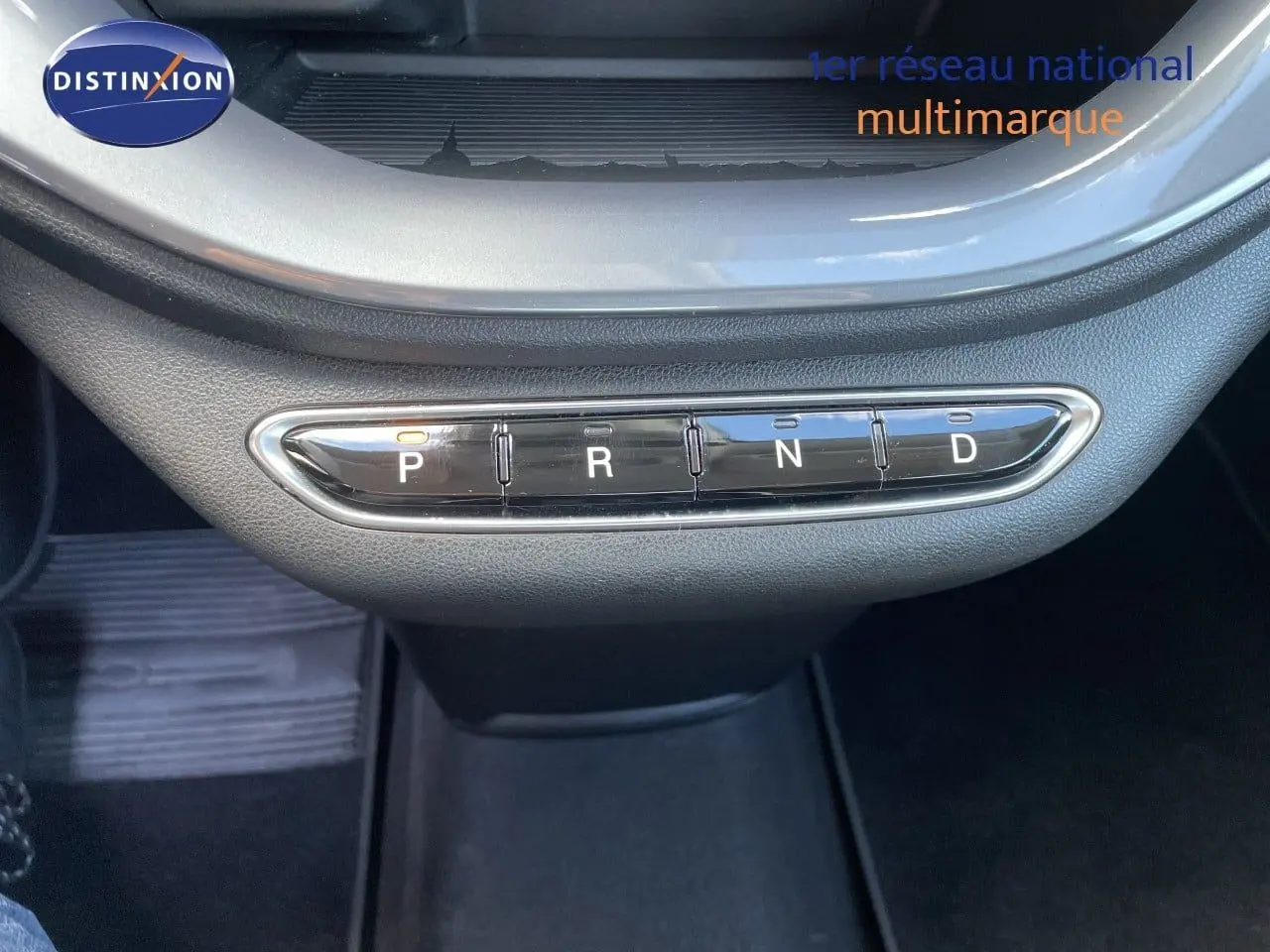Gros plan sur la commande de boîte automatique avec boutons P, R, N, D dans l’habitacle noir d’une Fiat 500 électrique 2023.