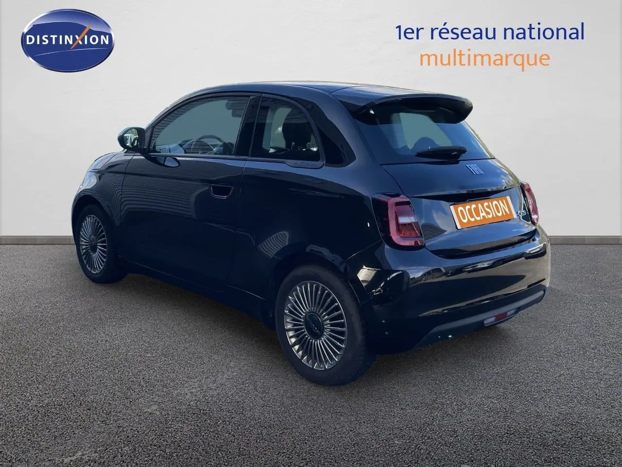 Vue 3/4 arrière droite d'une Fiat 500 électrique 2023 noir onyx avec jantes spécifiques et toit noir brillant.