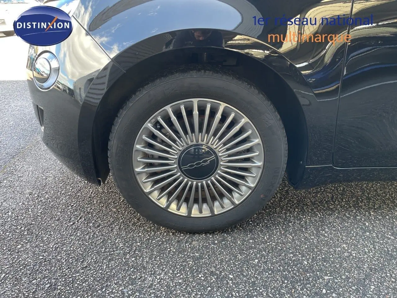 Gros plan sur la roue avant gauche de la FIAT 500 électrique 2023 noir onyx avec jante alliage distinctive.