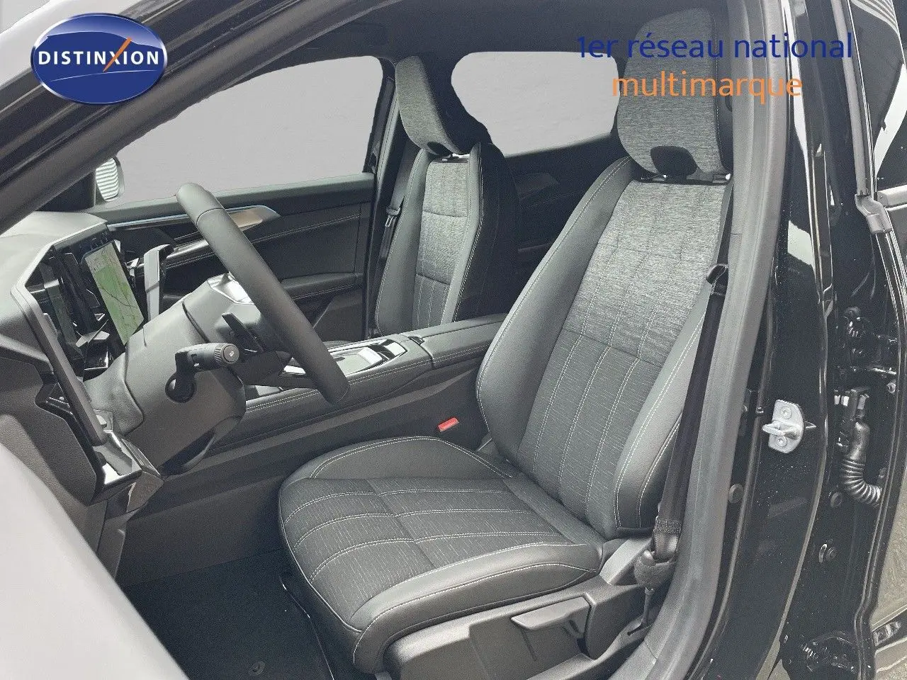 Vue intérieure côté conducteur du Renault Austral 2025 noir étoile métal, sièges tissu et cuir noir avec tableau de bord moderne.