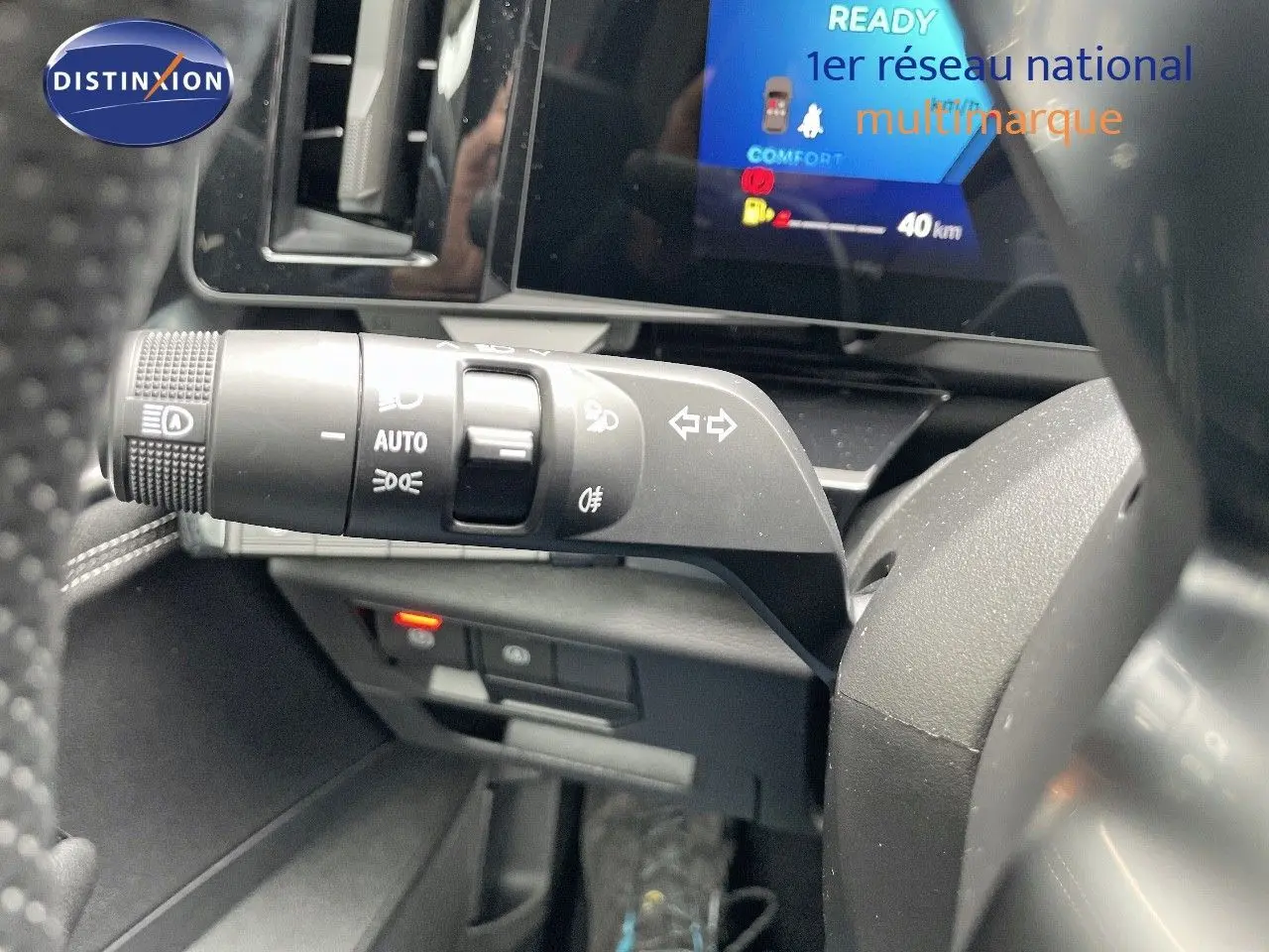 Gros plan sur la commande des phares et clignotants à gauche du volant dans le tableau de bord noir du Renault Austral 2025.