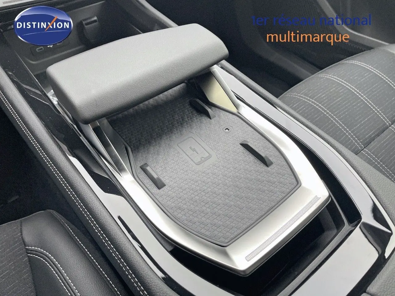 Vue rapprochée de la console centrale noire du Renault Austral E-Tech Hybrid 2025 avec surface de charge sans fil.