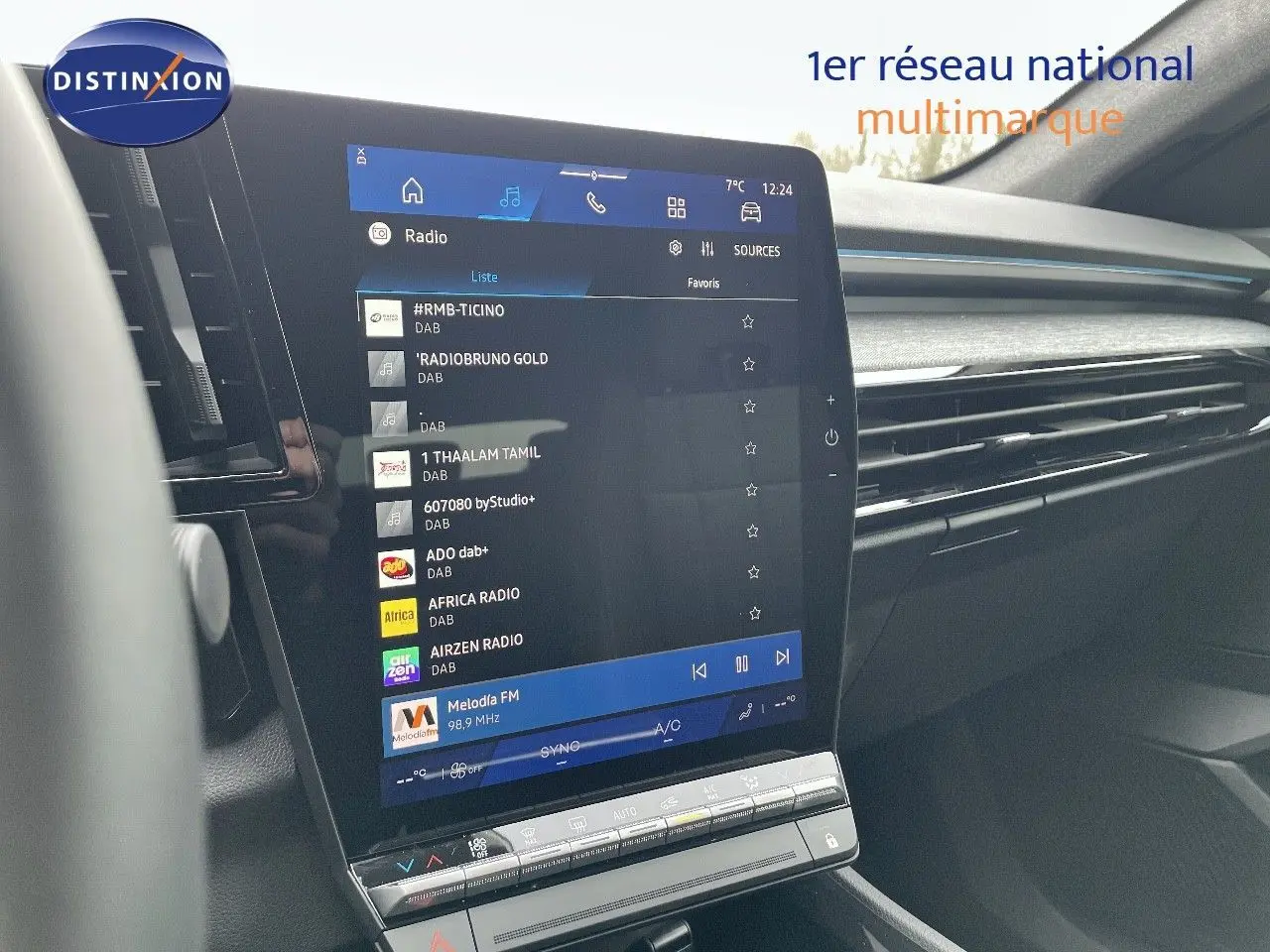Vue intérieure centrée sur l'écran tactile du tableau de bord du Renault Austral noir étoile métal, affichant la radio numérique.