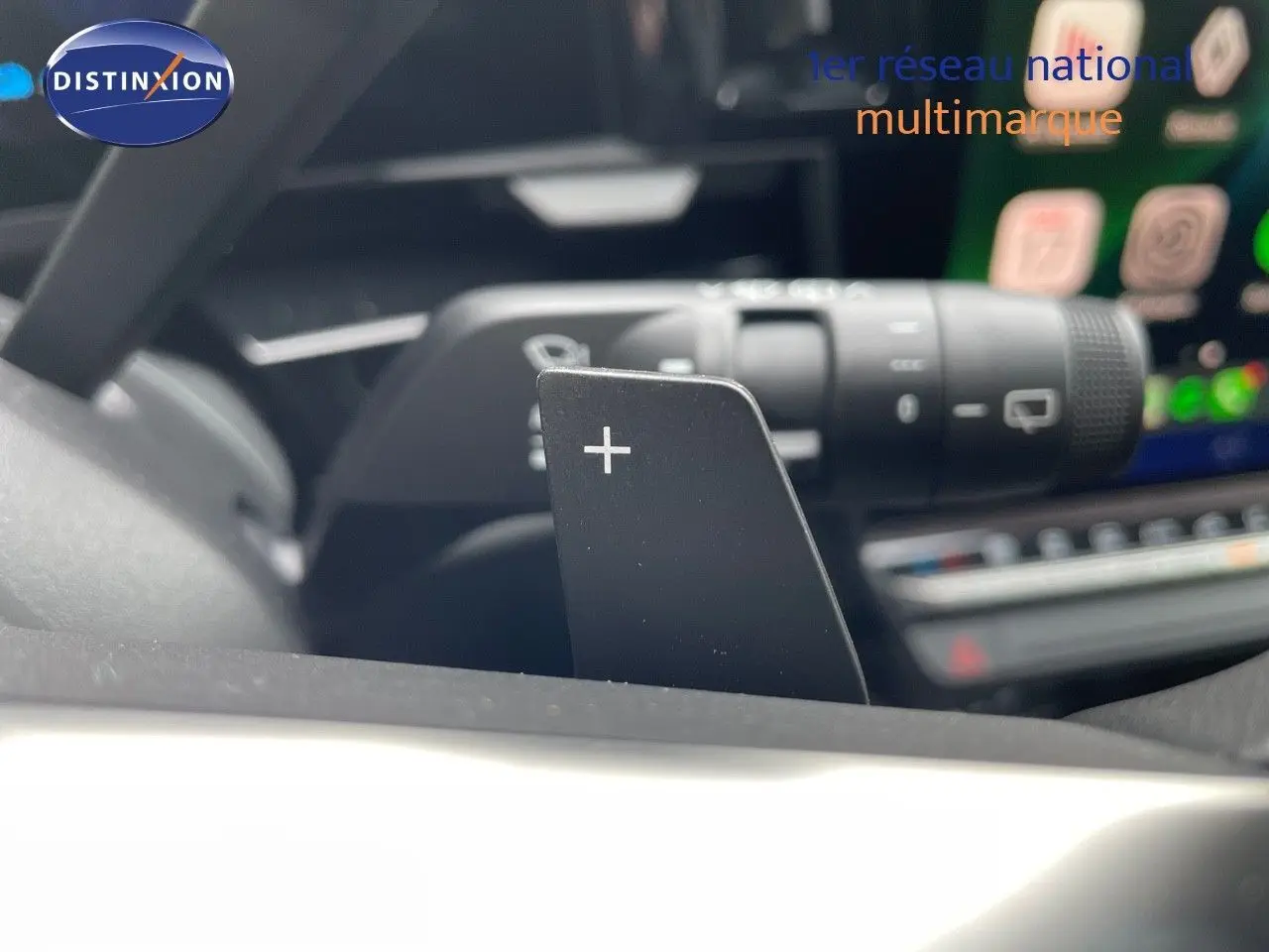 Gros plan sur la palette de changement de vitesse "+" du volant d'un Renault Austral noir étoile métal, intérieur moderne.