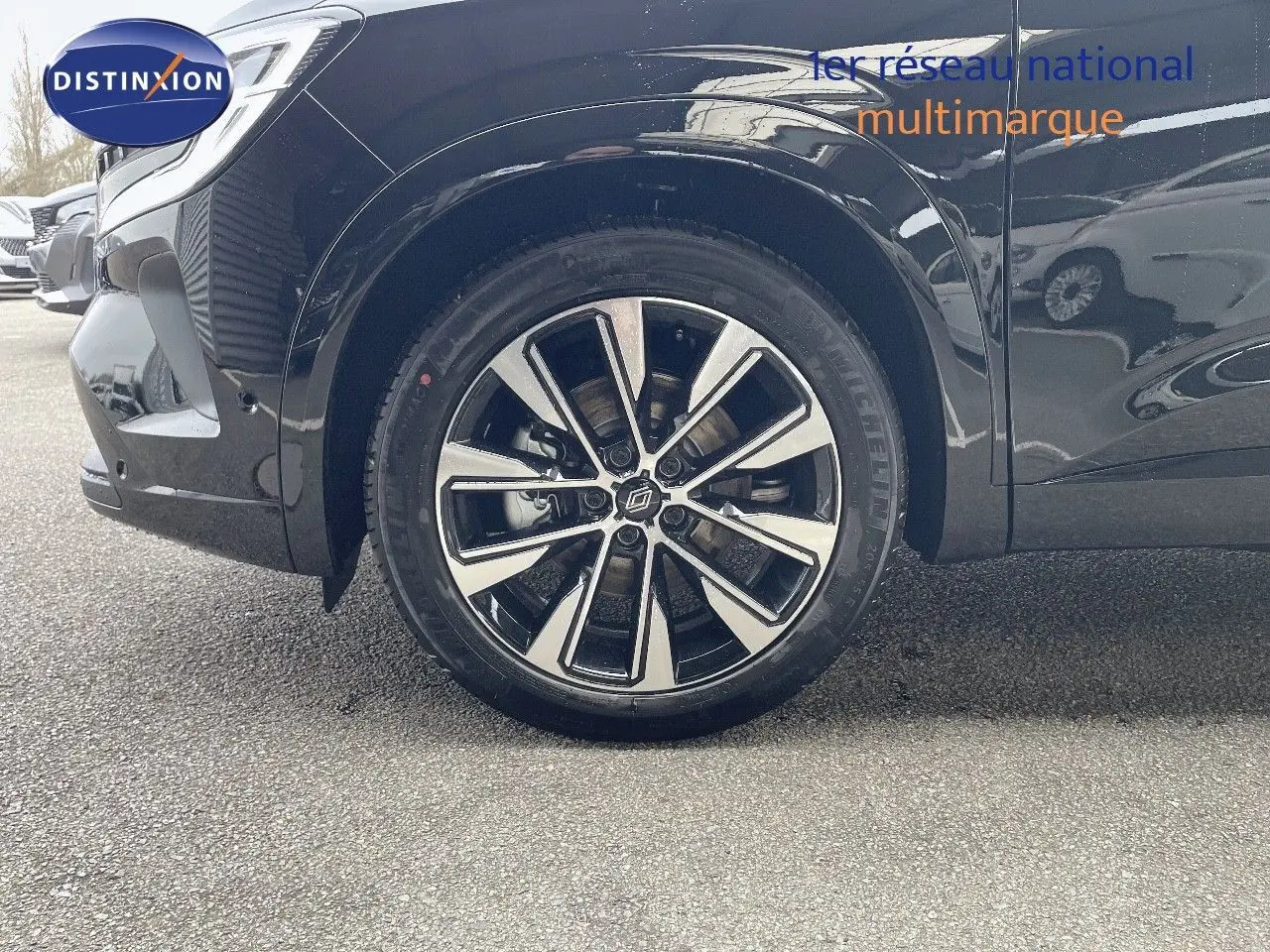 Gros plan sur la roue avant gauche du Renault Austral noir étoile métal avec jante alliage bicolore design moderne.