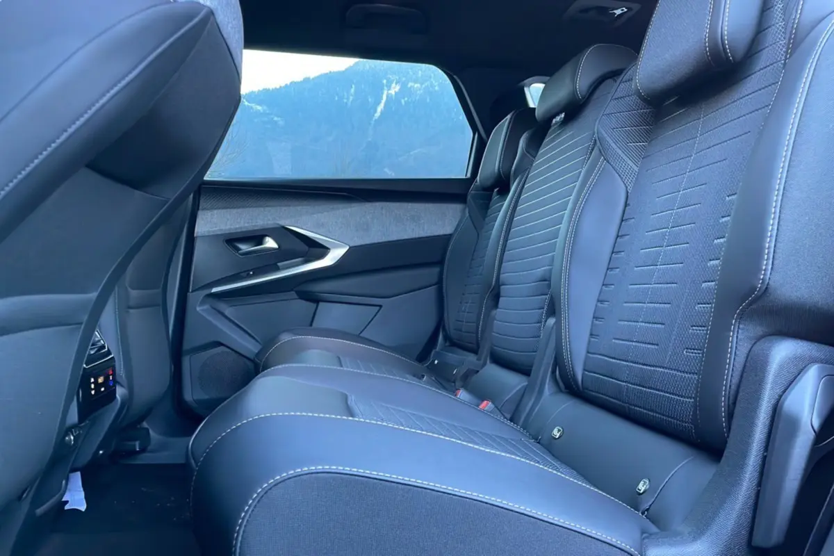 Vue latérale intérieure des sièges arrière en cuir noir avec surpiqûres blanches du Peugeot 5008 Hybrid 2025 gris titane
