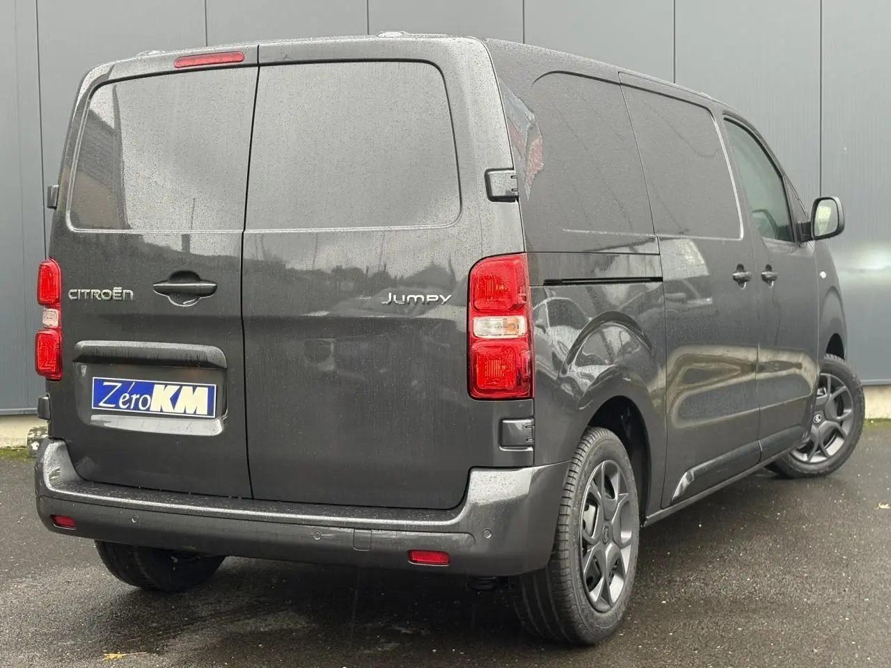 Vue 3/4 arrière droite d'un Citroën Jumpy gris titane avec portes arrière battantes et jantes noires.