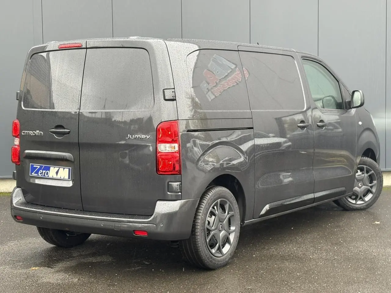 Vue 3/4 arrière droite d'un Citroën Jumpy gris titane avec portes arrière battantes et jantes noires.