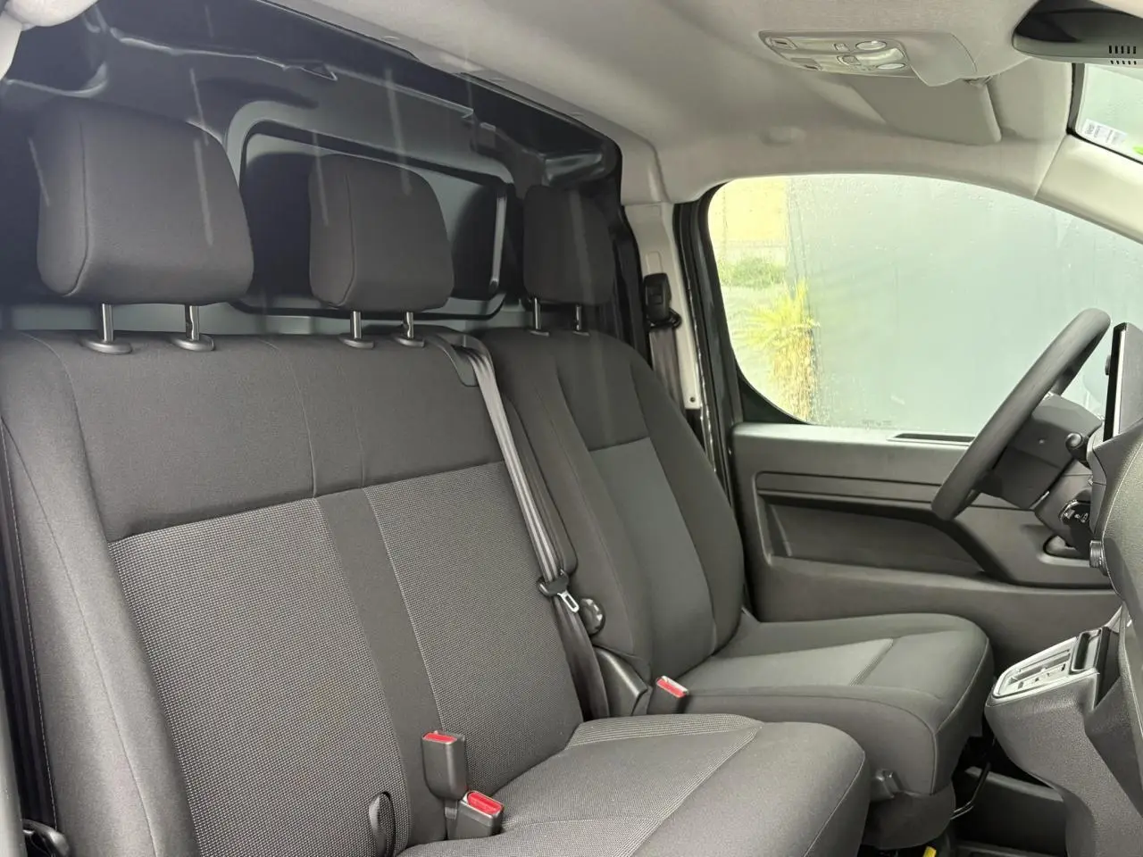 Vue intérieure côté conducteur du Citroën Jumpy 2025, montrant les sièges avant gris et le volant à droite.