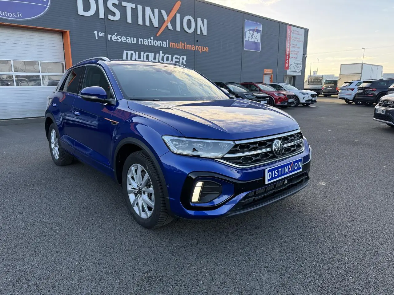 Volkswagen T-Roc 2.0 TDI R-Line bleu lapiz métallisé vu en 3/4 avant droit sur parking extérieur.