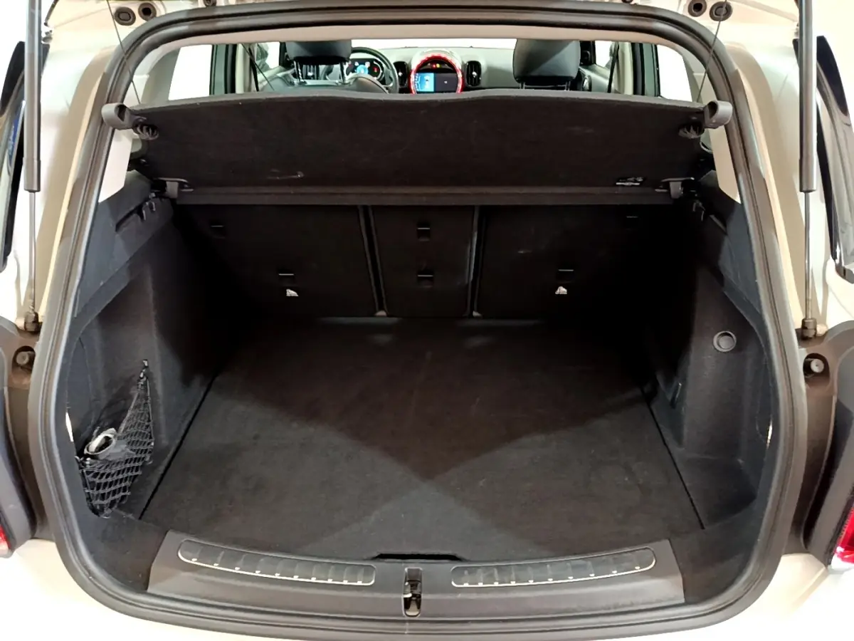 Coffre ouvert vu de l'arrière d'une MINI Countryman gris clair, avec banquette arrière et tableau de bord visibles.