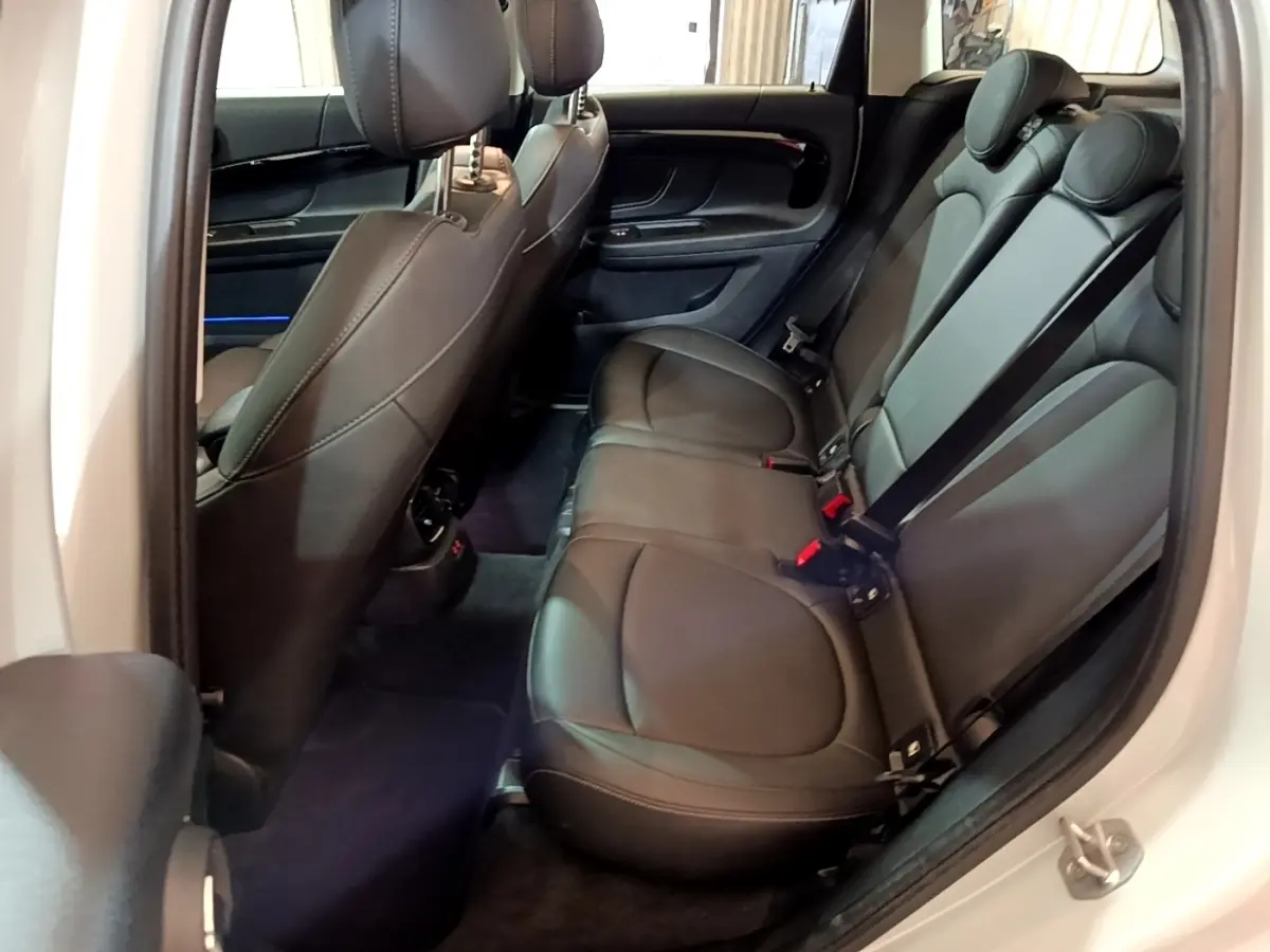 Vue intérieure côté droit des sièges arrière en cuir noir du MINI Countryman gris clair 2022, avec ceinture de sécurité visible.
