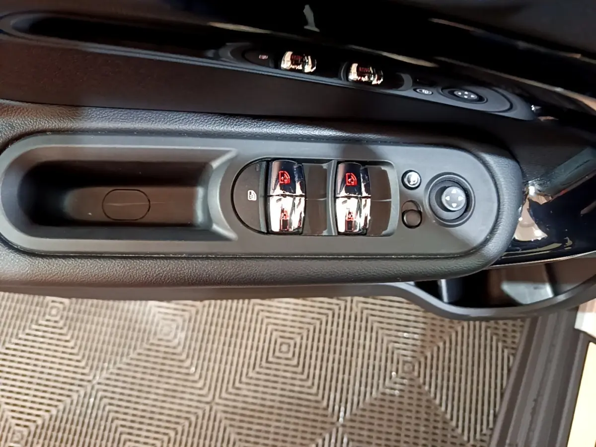 Gros plan sur les commandes de lève-vitres et rétroviseurs côté conducteur de la MINI Countryman gris clair 2022.