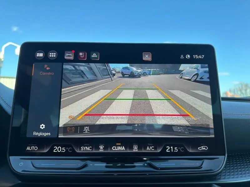 Vue depuis la caméra de recul du tableau de bord du CUPRA Formentor blanc Nevada métallisé, affichant une zone de stationnement.