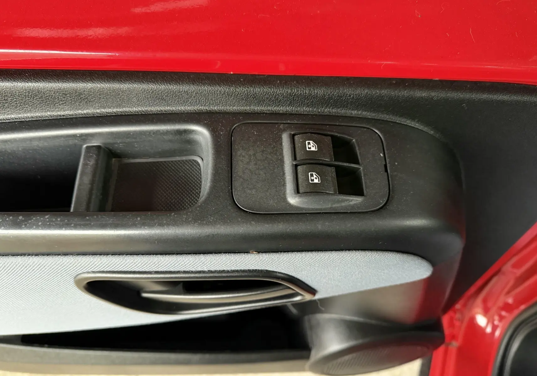 Gros plan sur la commande des vitres électriques côté gauche d'une porte rouge de Peugeot Bipper Tepee 2013.