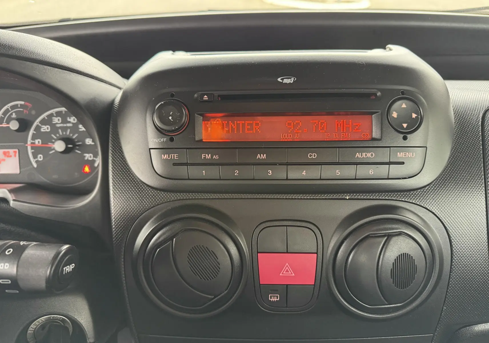 Tableau de bord et radio MP3 du Peugeot Bipper Tepee 2013, vue centrée sur les commandes et l'écran rouge.