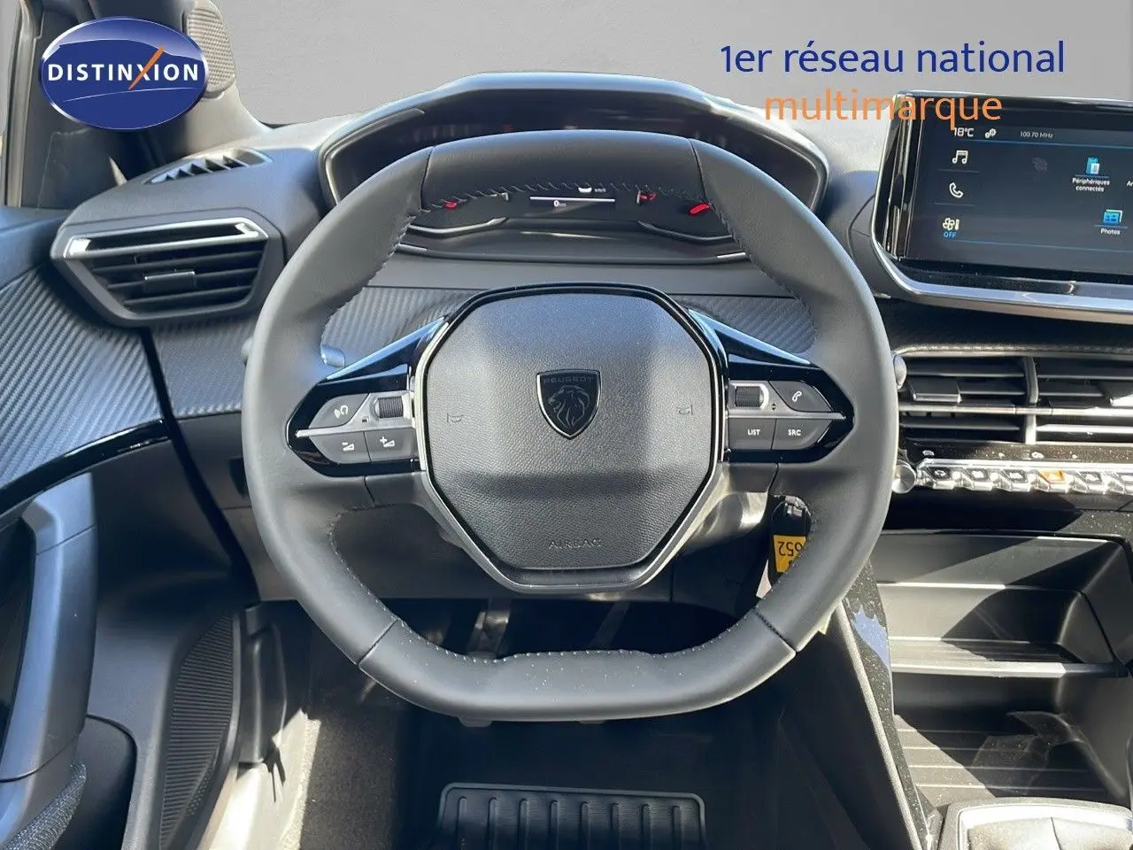 Vue rapprochée du volant noir du Peugeot 2008 2025 avec tableau de bord et écran tactile moderne.