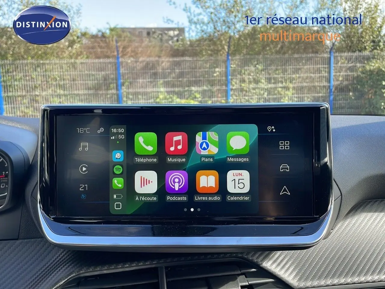 Écran tactile central affichant Apple CarPlay dans l'habitacle d'une Peugeot 2008 blanche vue de face.
