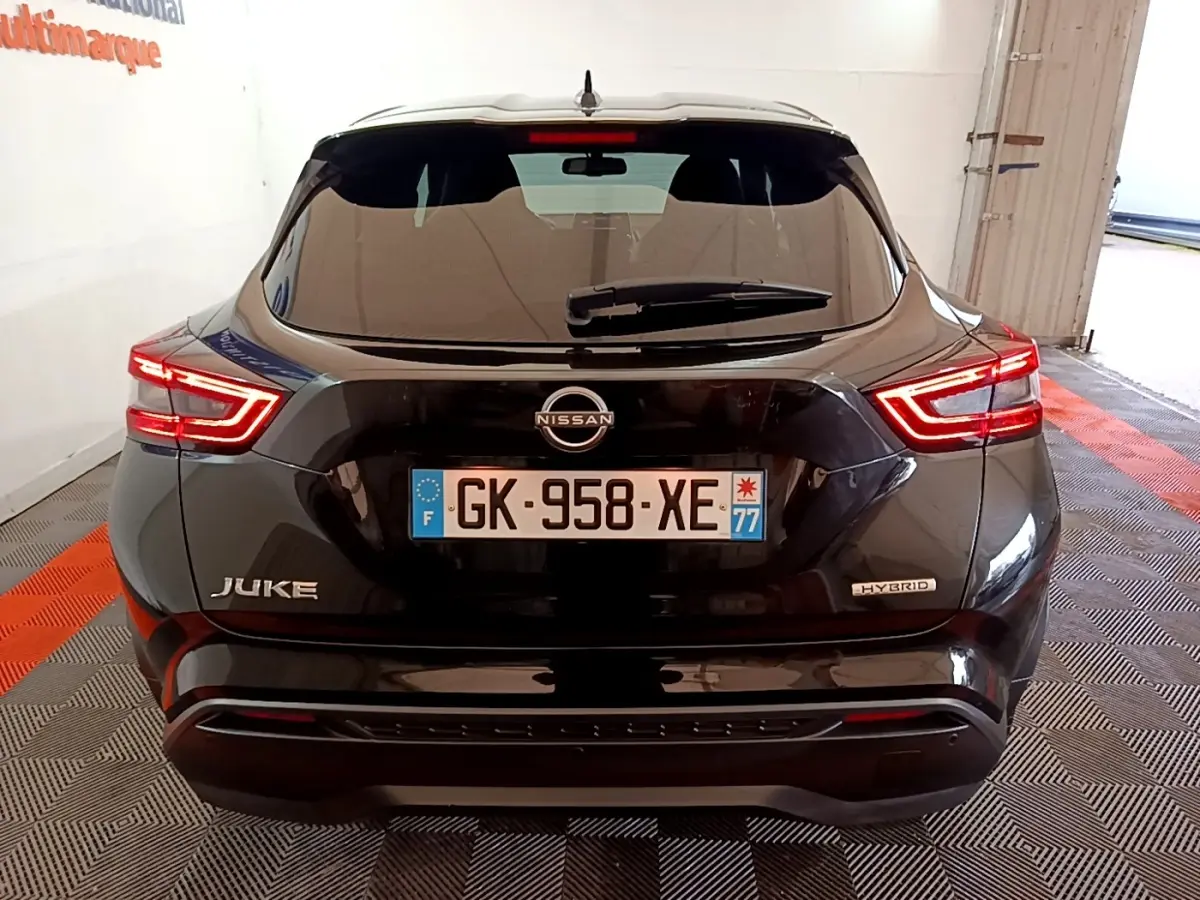 Vue arrière d'un Nissan Juke Hybrid noir 2022 avec feux LED allumés et badges Juke et Hybrid visibles.