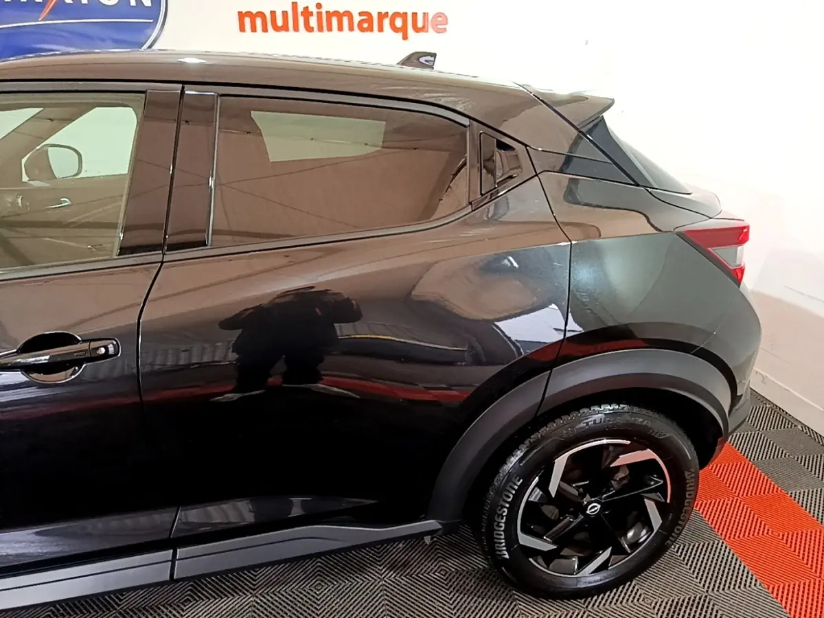 Vue latérale droite du Nissan Juke Hybrid 143 Business+ noir, mettant en valeur la jante noire et la ligne de caisse dynamique.