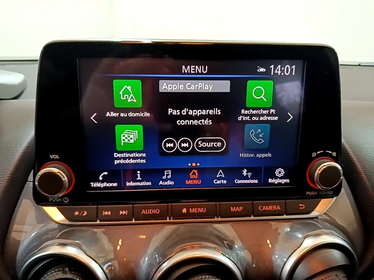 Écran tactile central 8 pouces du Nissan Juke Hybrid 2022 affichant le menu Apple CarPlay, avec commandes audio en dessous.