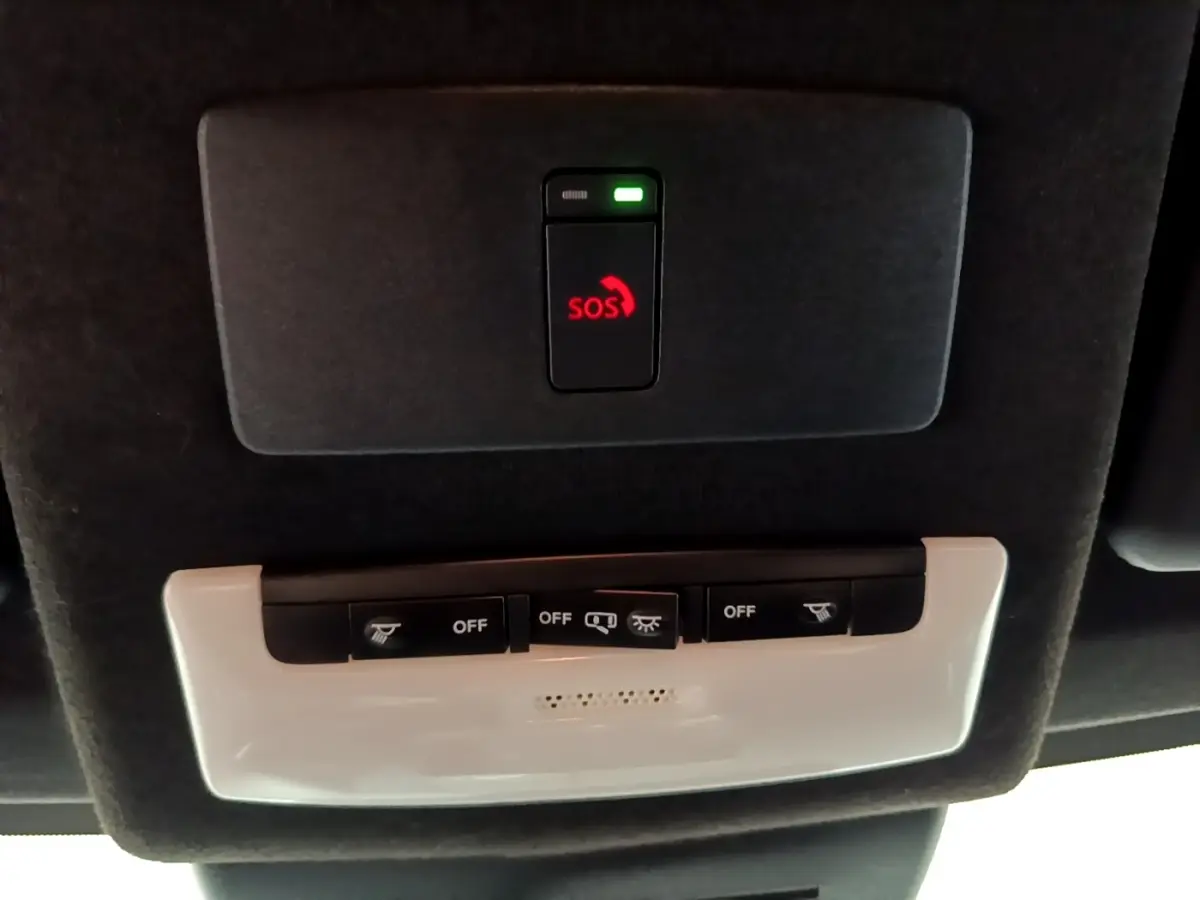 Vue en gros plan du plafonnier noir avec bouton SOS rouge et commandes d'éclairage du Nissan Juke Hybrid 2022.