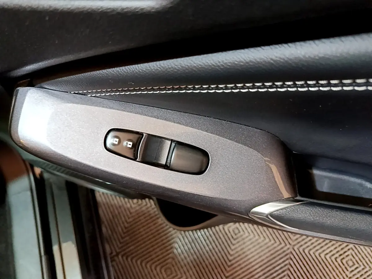 Détail de la commande de verrouillage des portes sur la porte intérieure côté conducteur du Nissan Juke Hybrid noir 2022.