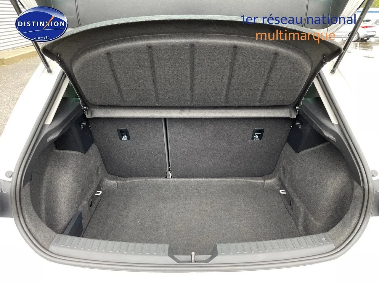 Coffre ouvert d'une SEAT LEON blanche 2024, vue de l'arrière montrant un espace de chargement propre et spacieux.