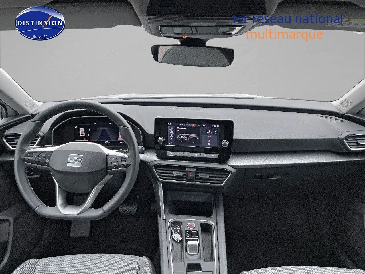 Intérieur moderne de la SEAT LEON IV blanche, vue frontale sur le tableau de bord et volant multifonction.