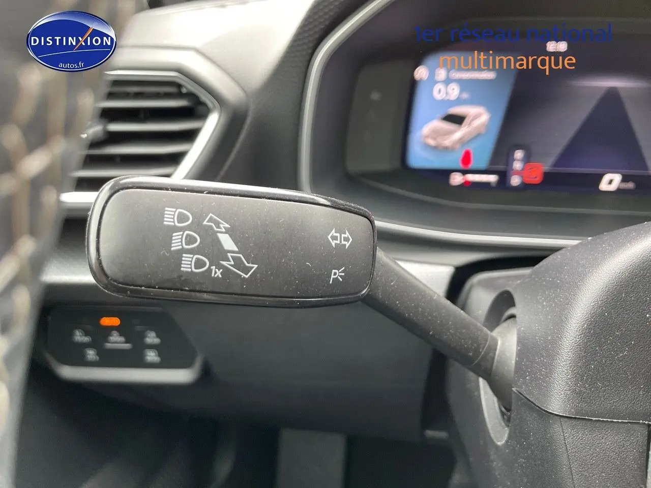 Le commodo de clignotants et feux du SEAT Leon IV visible en gros plan côté gauche du volant, tableau de bord en arrière-plan.