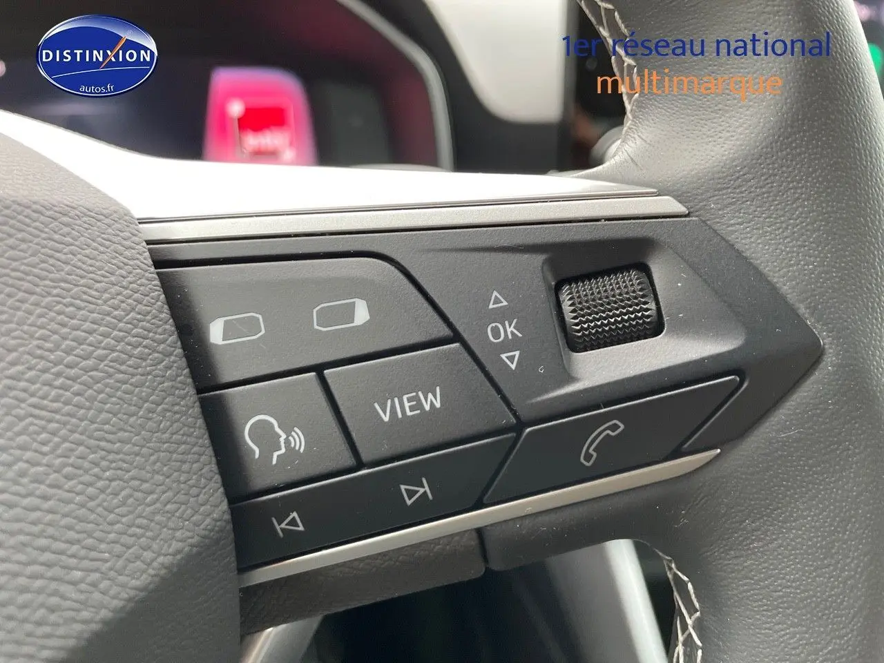 Gros plan sur les commandes multifonctions du volant en cuir gris du SEAT LEON IV blanc, version 2024.