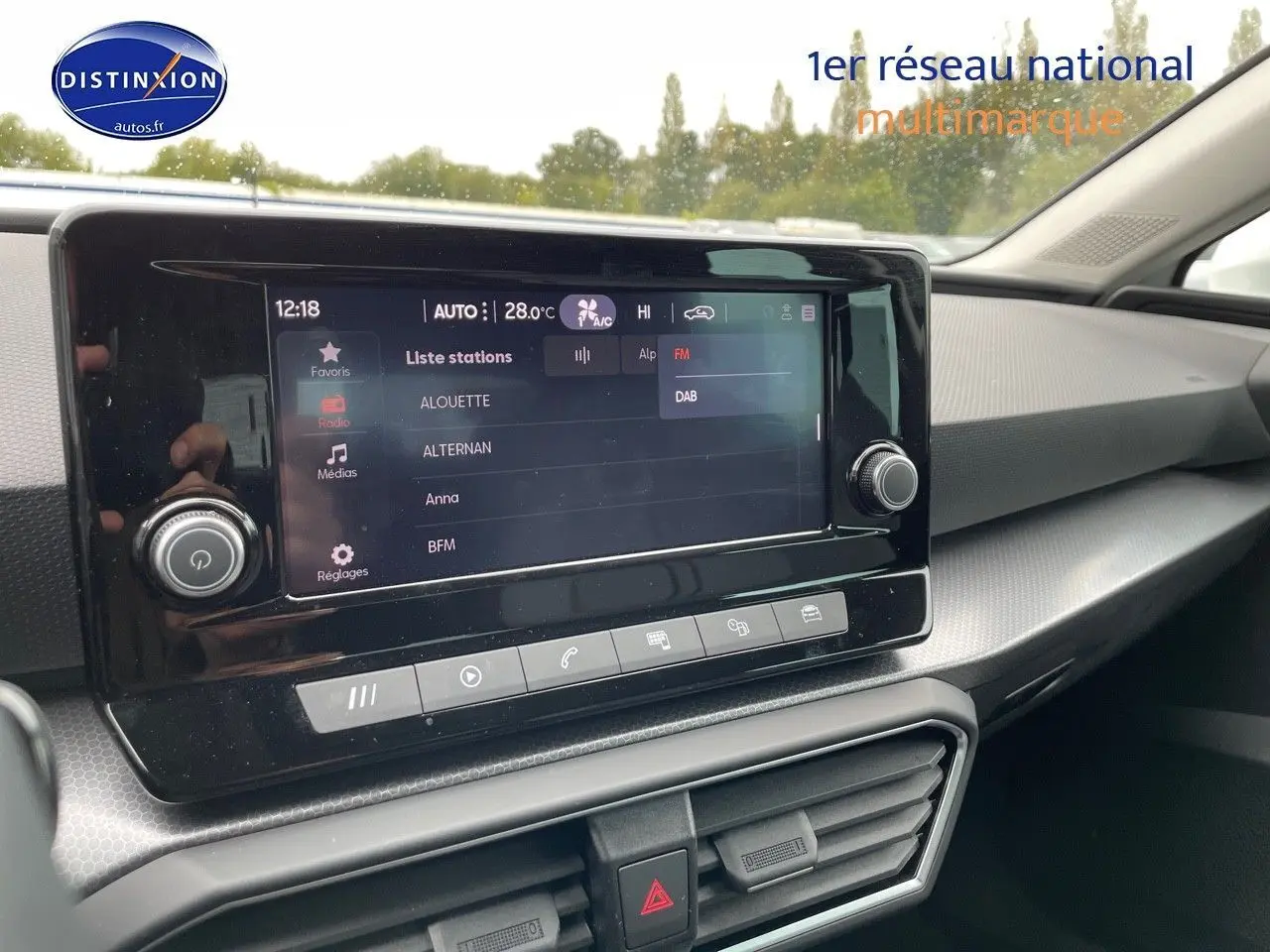 Tableau de bord et écran tactile du SEAT Leon blanc 2024, vue intérieure côté passager mettant en valeur l'interface multimédia.