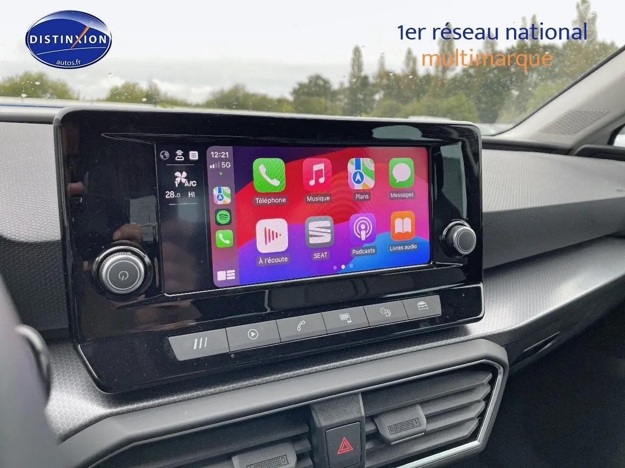 Écran tactile central du tableau de bord d'une SEAT Leon blanche 2024, avec interface connectée colorée.