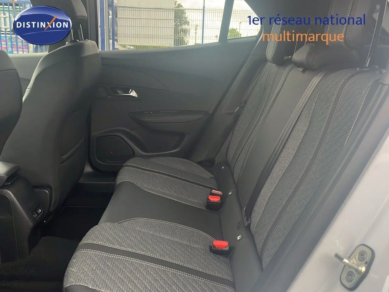 Vue latérale droite de l'intérieur arrière du Peugeot 2008 blanc Okenite, sièges tissu noir avec surpiqûres claires.