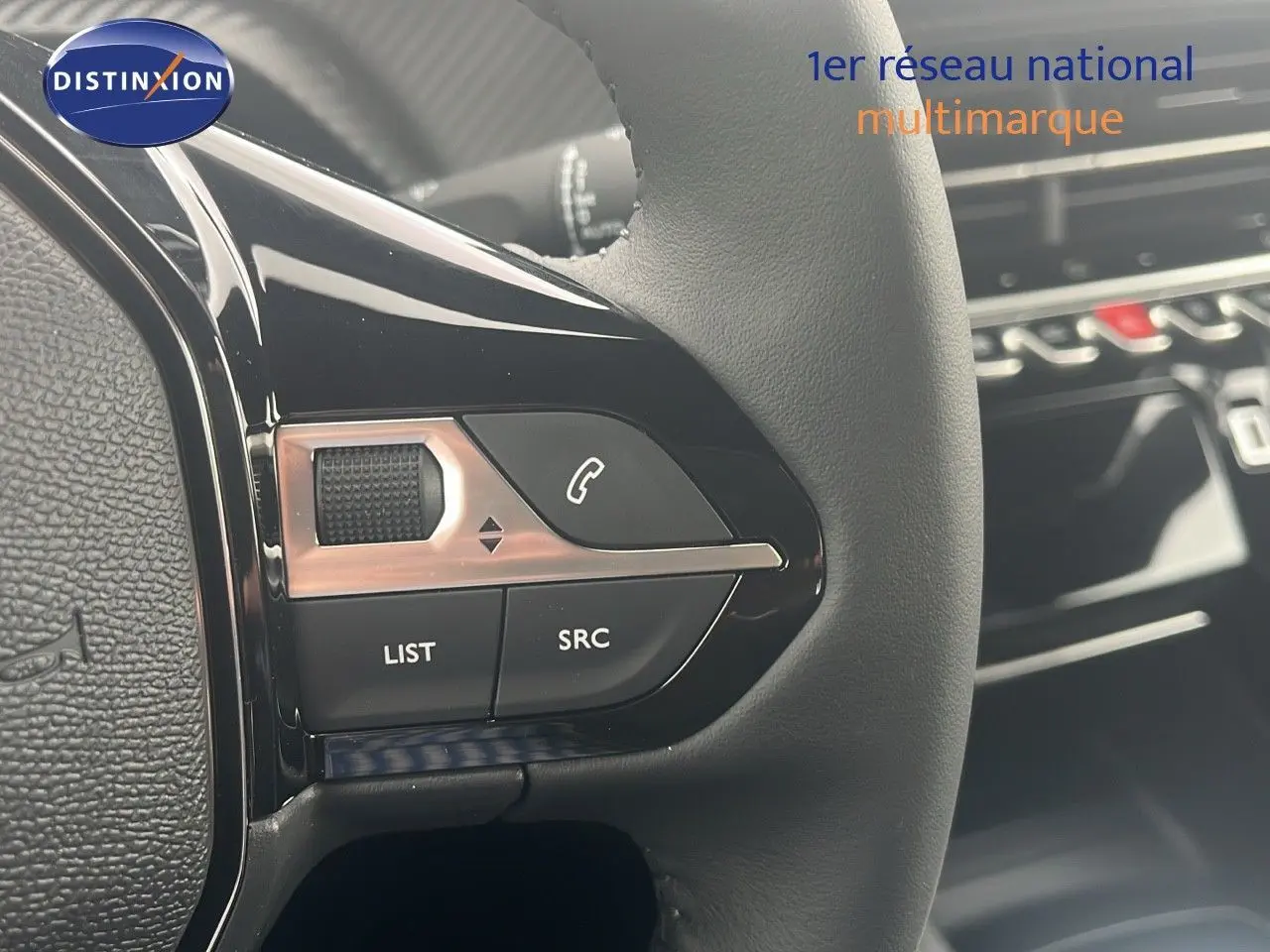 Gros plan sur les commandes du volant d'une Peugeot 2008 blanche 2025, mettant en valeur les boutons de contrôle audio et appel.