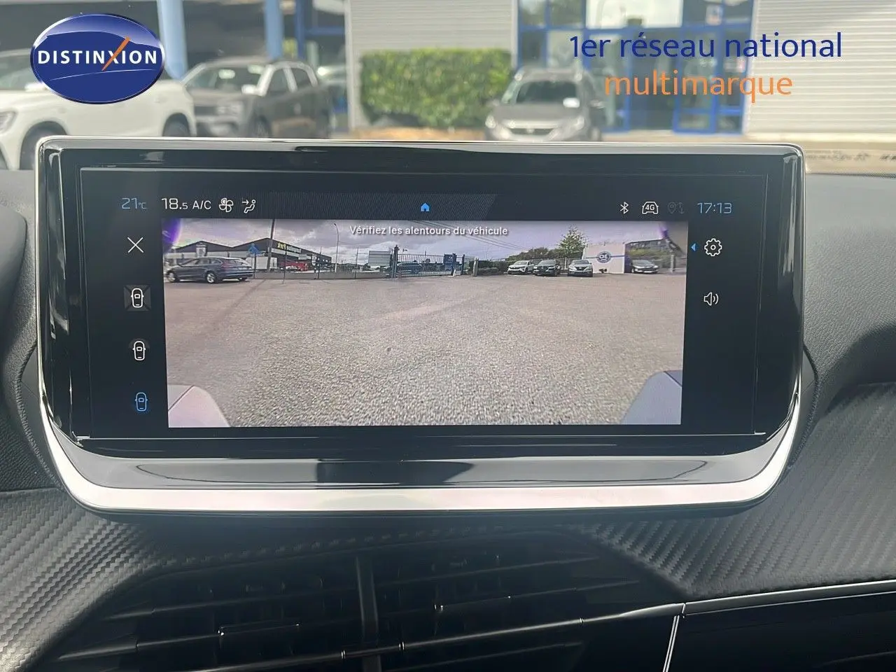 Écran intérieur affichant la caméra de recul du Peugeot 2008 blanc Okenite, vue depuis le poste de conduite.