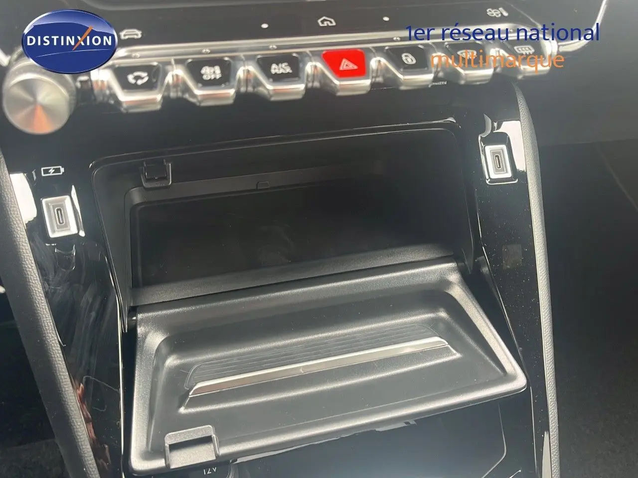 Gros plan sur la console centrale noire du Peugeot 2008 2025, avec rangements ouverts et commandes en chrome.