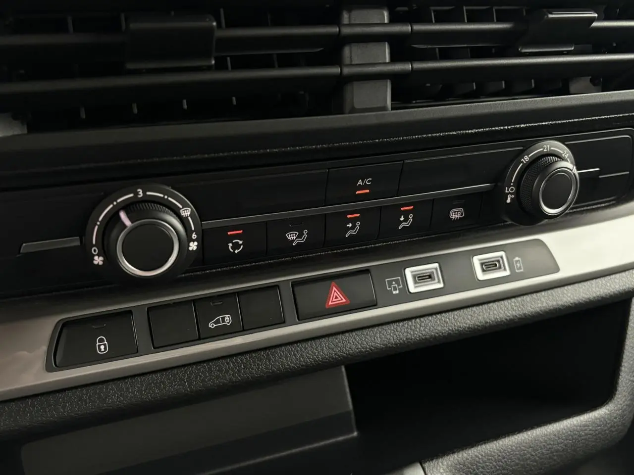 Détail de la console centrale du Citroën Jumpy noir, montrant les commandes de climatisation et boutons fonctionnels.