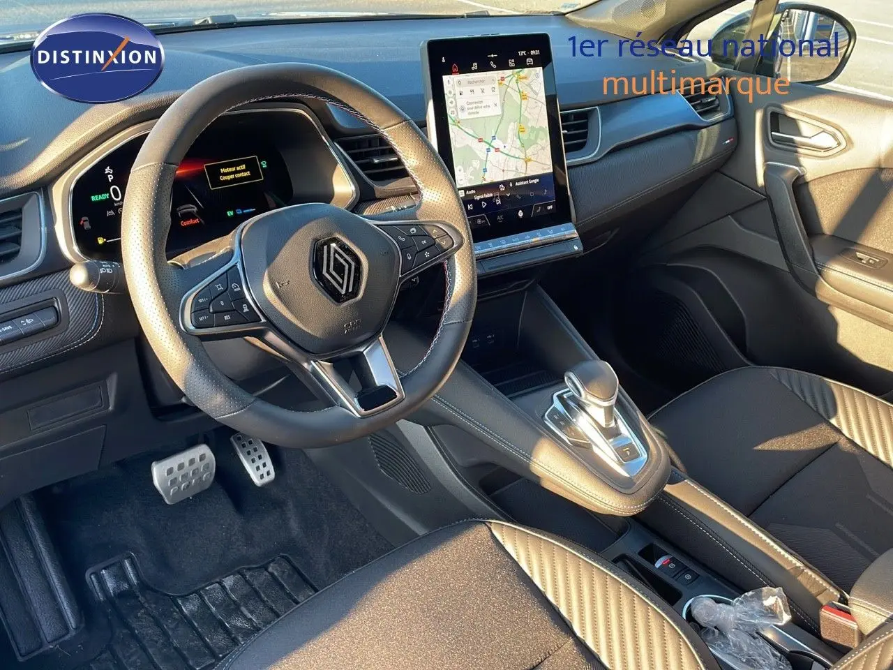 Vue intérieure avant du Renault Captur E-Tech Hybrid 2025, volant multifonction et écran tactile central lumineux.