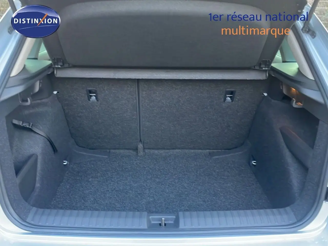Coffre ouvert vu de l'arrière d'un Skoda Kamiq gris argent métal 2025, espace de chargement vide et propre.