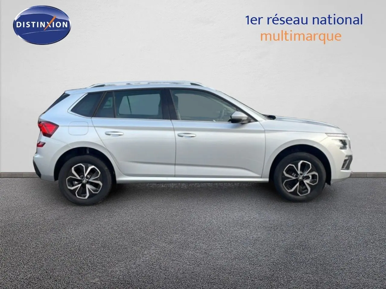 Profil côté droit d'un Skoda Kamiq gris argent métal 2025 avec jantes alliage et lignes épurées sur fond neutre.